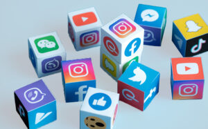 Colorful toy blocks scattered playfully, each bearing logos of popular social media platforms like Facebook, Instagram, Twitter, YouTube, TikTok, and others, representing the fun and engaging nature of navigating social media marketing