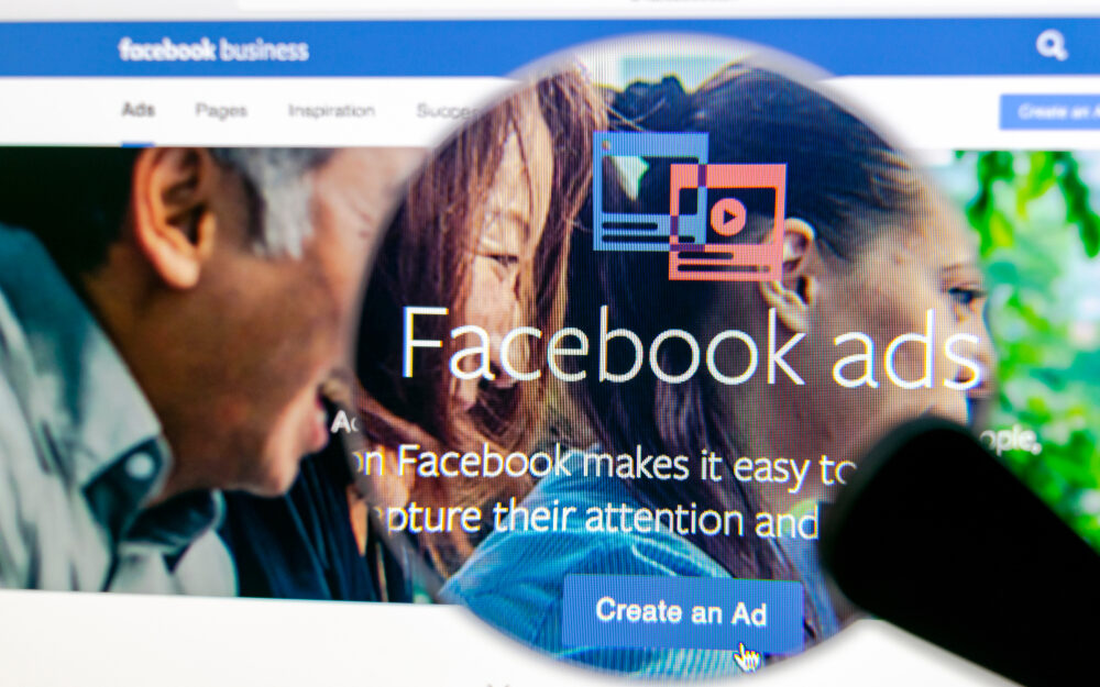 Close-up view of a computer screen displaying Facebook Ads homepage, highlighting the 'Create an Ad' button, with a focus on digital marketing and user engagement.