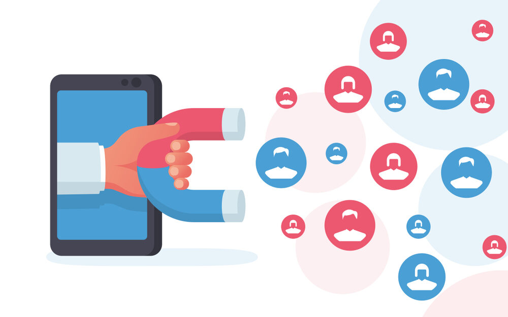 A stylized illustration showing a red magnet coming out of a smartphone screen, attracting blue icons representing user profiles. The graphic symbolizes the concept of drawing clients or customers digitally through targeted online strategies.